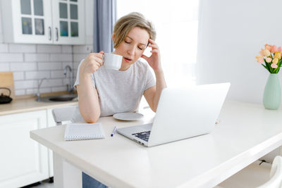 Young woman drinking coffee cup on table