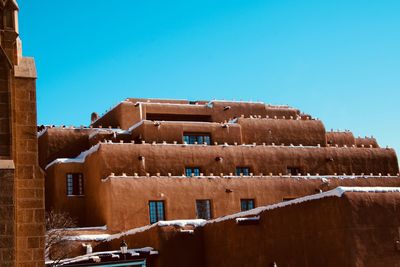 Low angle view of old building against clear blue sky