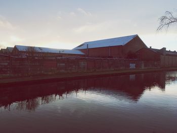 Reflection of built structure in water against sky