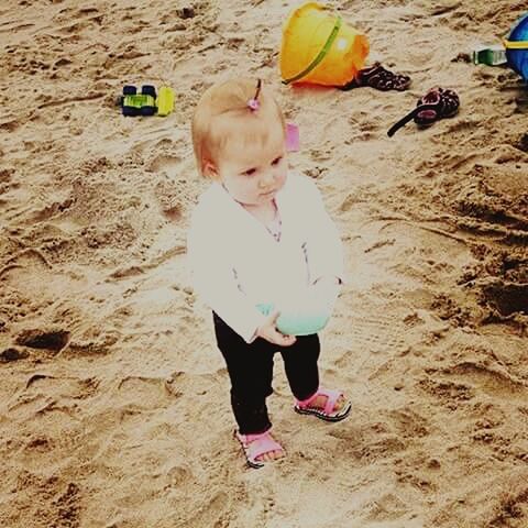 GIRL PLAYING ON SAND AT PARK