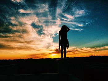 Silhouette woman against sky during sunset