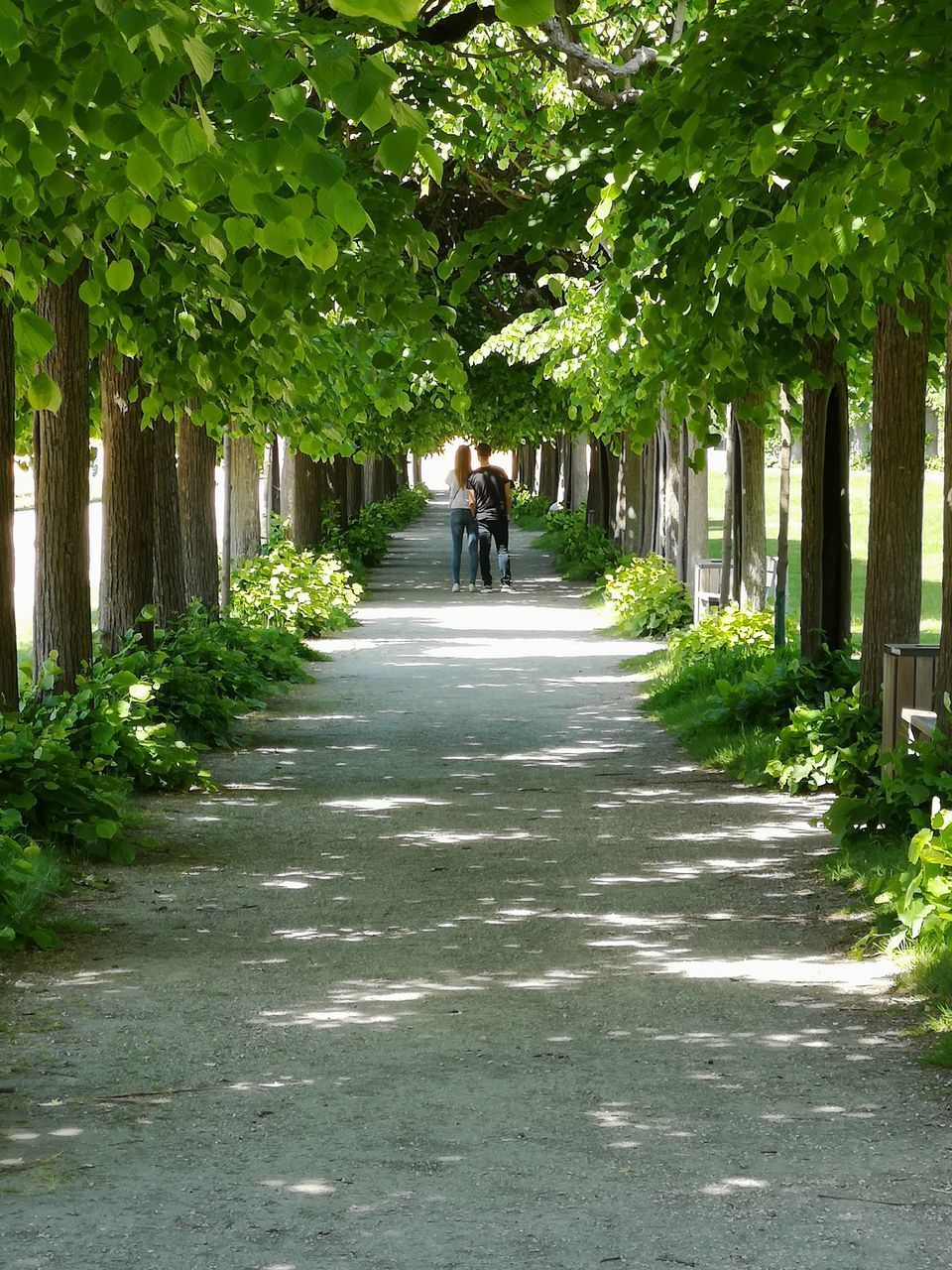 REAR VIEW OF A WOMAN WALKING ON ROAD