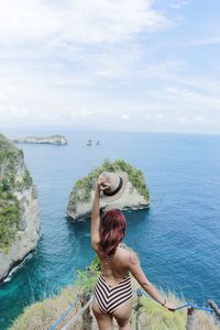 Rear view of young woman looking at sea