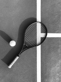 High angle view of racket with tennis ball on court