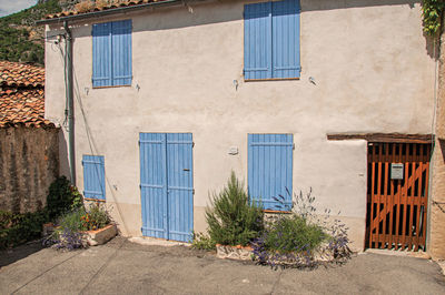 View of house with blue shutters closed at moustiers-sainte-marie, in the french provence.