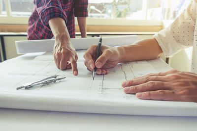 Midsection of architects working at desk in office