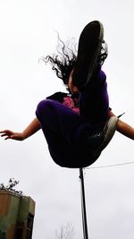 Low angle view of woman standing against sky