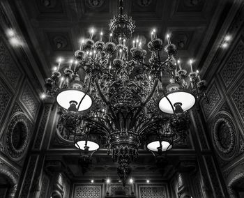 Low angle view of illuminated chandelier hanging from ceiling