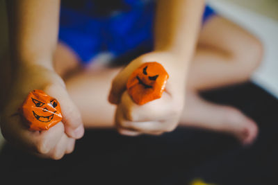 Close-up of orange person holding pumpkin