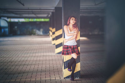 Portrait of smiling young woman standing against blurred background