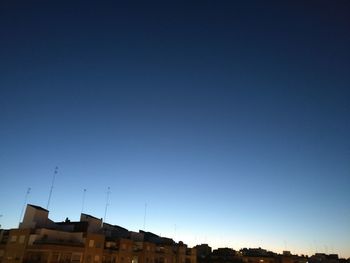 Low angle view of buildings against clear blue sky