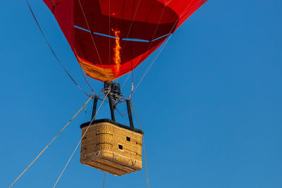 Low angle view of hot air balloon against clear blue sky