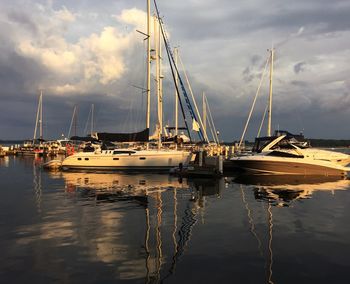 Boats moored at harbor against sky