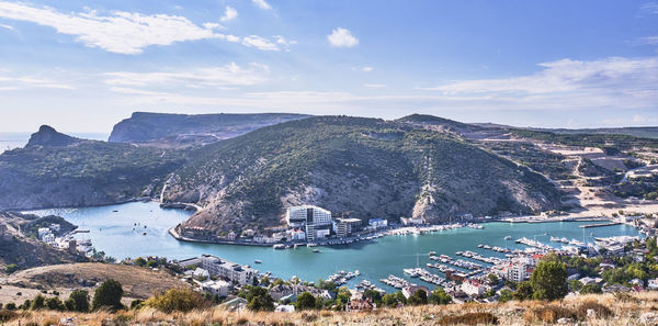 High angle view of sea by mountains against sky