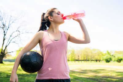 Midsection of woman drinking glass