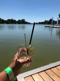 Midsection of man drinking water in lake