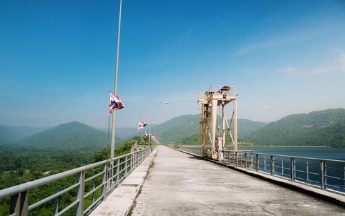 Bridge over mountain against blue sky