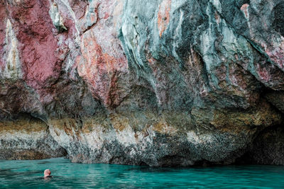 Woman swimming in river against rock formation