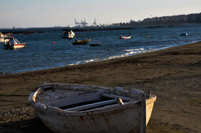 Boats moored on beach against sky