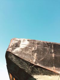 Low angle view of old boat against clear blue sky