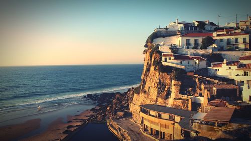 High angle view of buildings by sea against clear sky