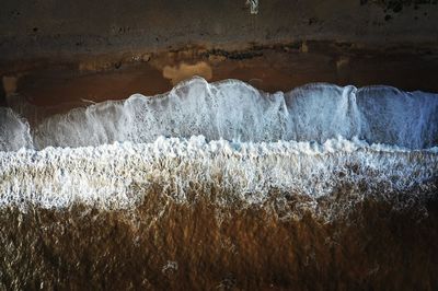 Aerial view of waves crashing on the shore 