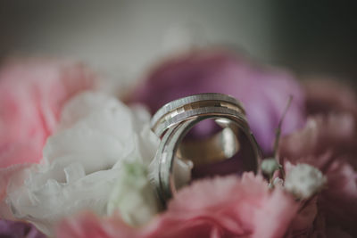 Close-up of wedding rings on pink flower