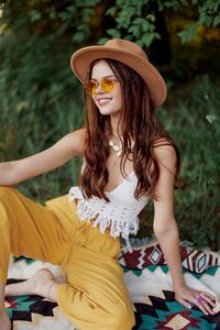 Young woman looking away while sitting at park