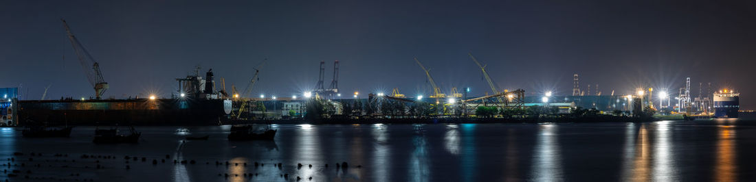 Panoramic night scene and long exposure shot container oil ship repair in shipyard 