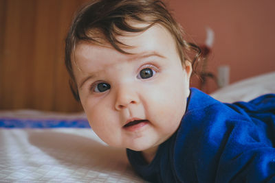 Close-up of baby girl on bed