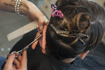 Cropped hands cutting woman hair