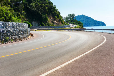 Surface level of empty road against calm sea