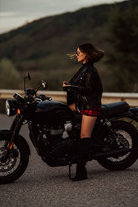 Side view of woman riding motorcycle on road