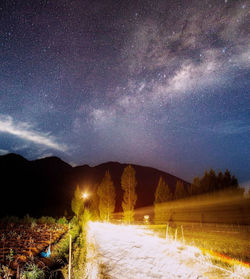 Scenic view of illuminated land against sky at night