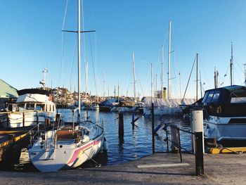 Sailboats moored at harbor