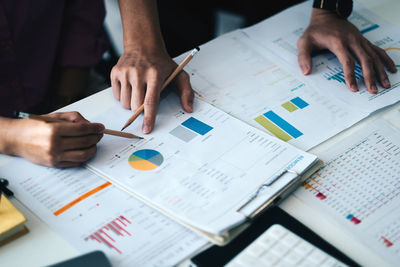 Midsection of business people working on table