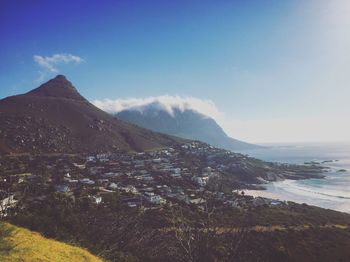 Scenic view of mountain and sea against blue sky