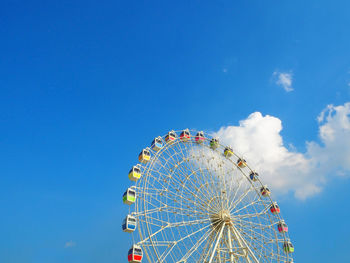 Low angle view of ferris wheel against blue sky