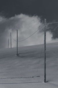 Electricity pylon on field against sky