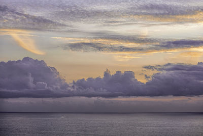 Scenic view of sea against sky at sunset with pink clouds