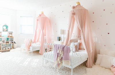 A sister room with pink canopies