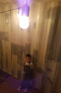 Full length of boy standing on illuminated smart phone