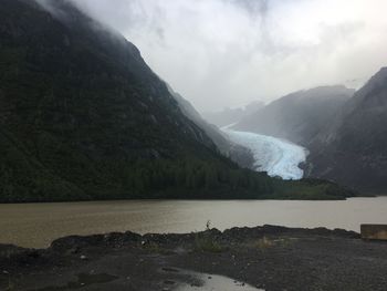 Scenic view of river and mountains against sky