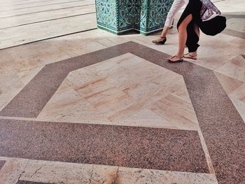 Low section of women walking on tiled floor