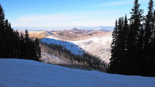 Scenic view of snow covered mountains against sky