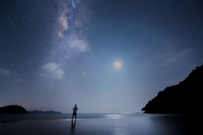 Digital composite of man standing on river against star field
