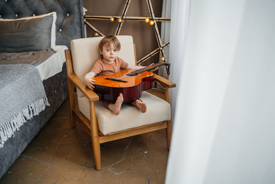 Little boy playing classical guitar. high quality photo