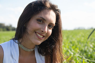 Portrait of smiling young woman against sky