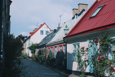 Houses amidst trees and buildings against sky