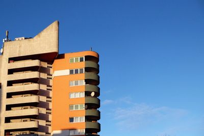 Low angle view of buildings against clear blue sky